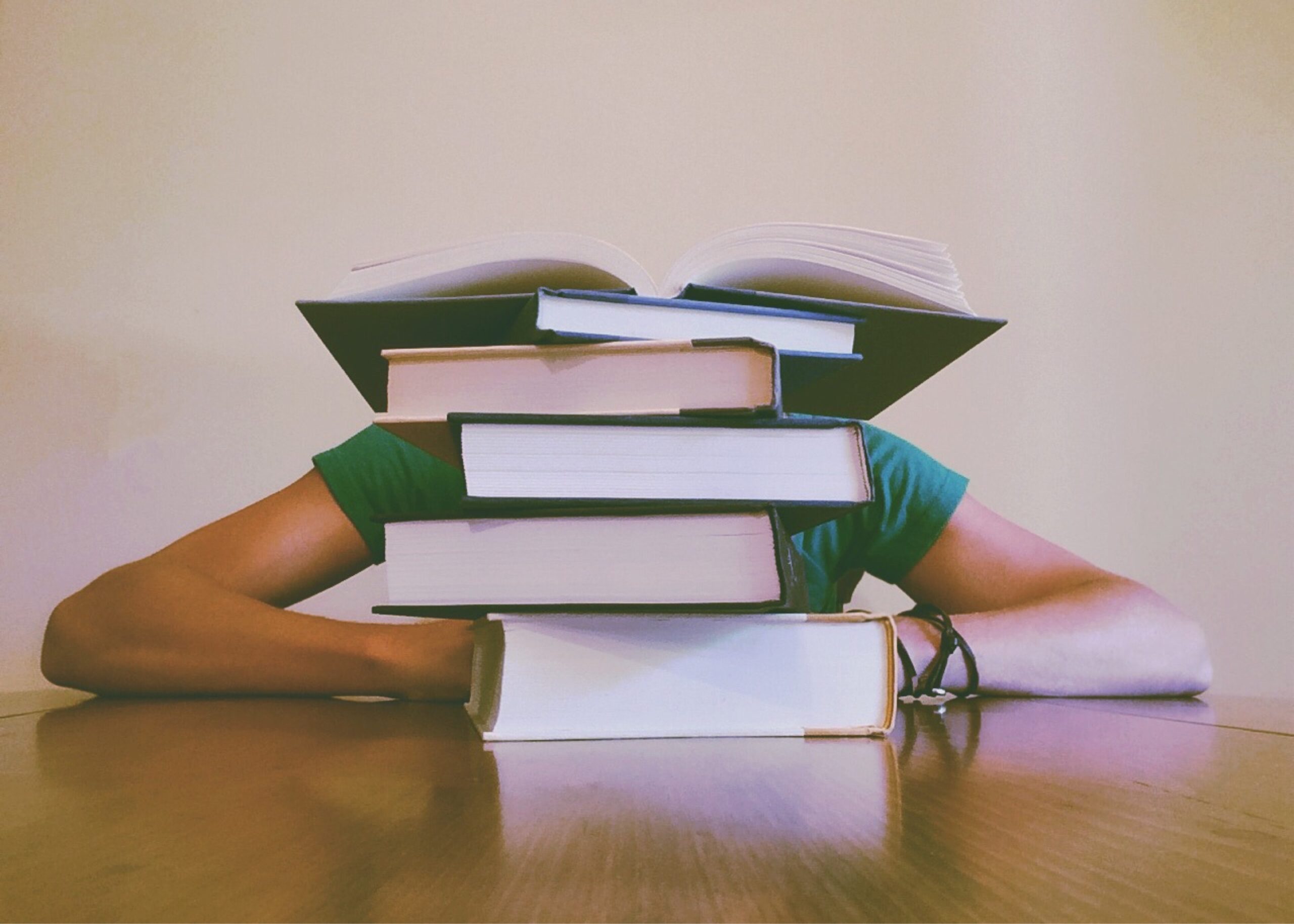Student sitting behind a stack of books