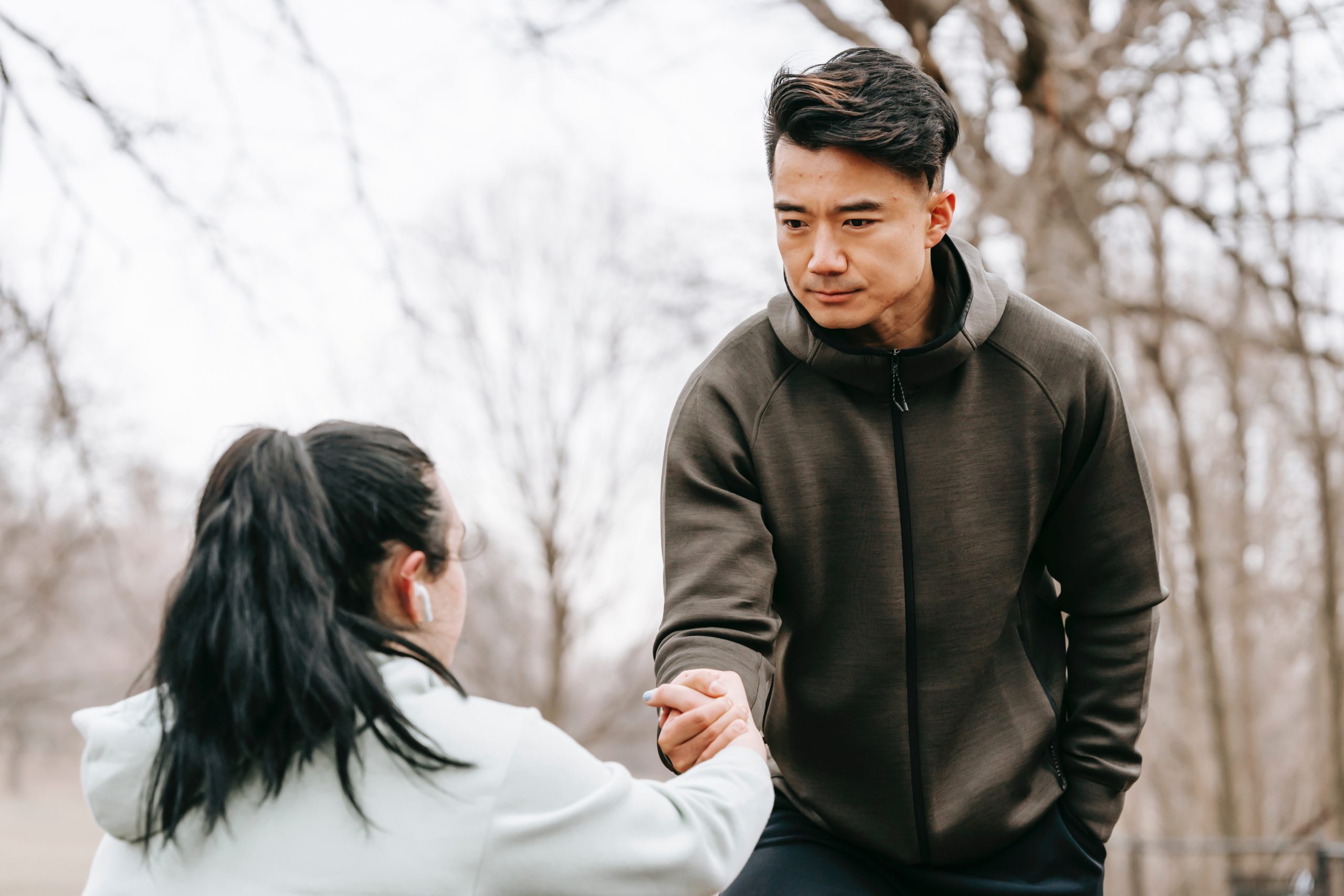 Man reaching out his hand to help a woman who is struggling