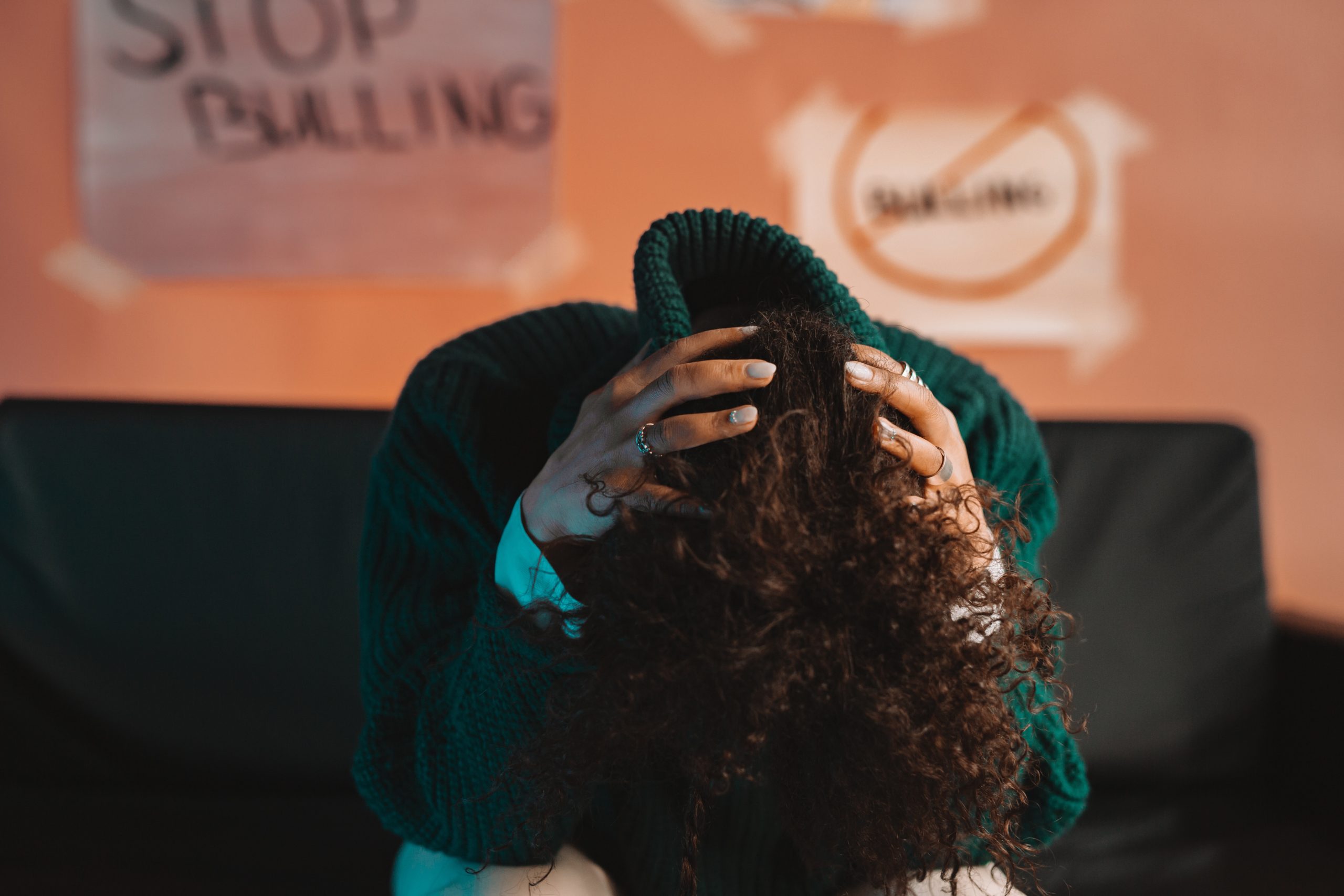 Woman sitting on a couch with her head in her lap