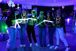 students at neon nights party wearing neon colored head, neck and wrist gear
