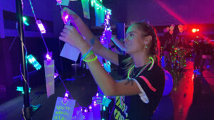 students dancing in the dark covered in neon colored glow in the dark wrist and neck gear