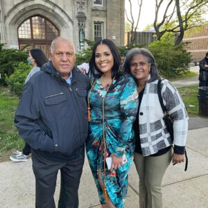 Brenda Leger and her parents smiling outside at her college graduation 
