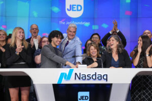JED staff, former interns and supporters standing in front of NASDAQ sign about to ring the bell