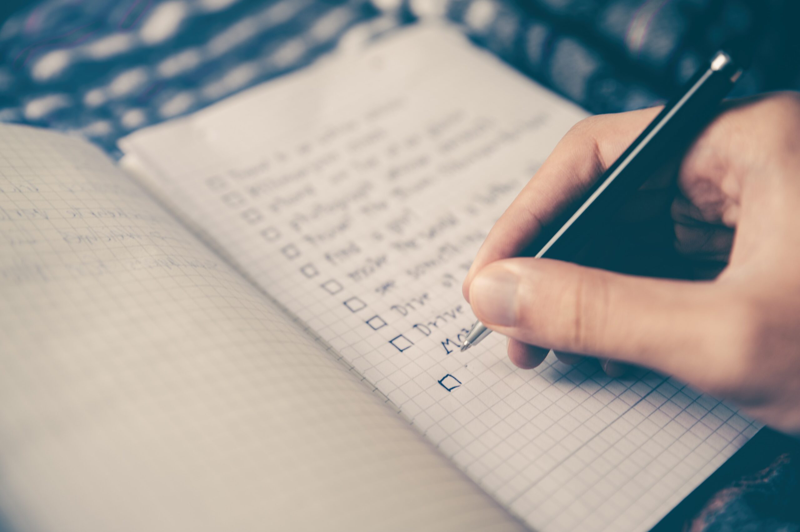 A person writing a checklist in a journal