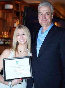 John Macphee and Adison standing together at The Jed Foundation Florida Gala, Adison is holding a certificate in her hand