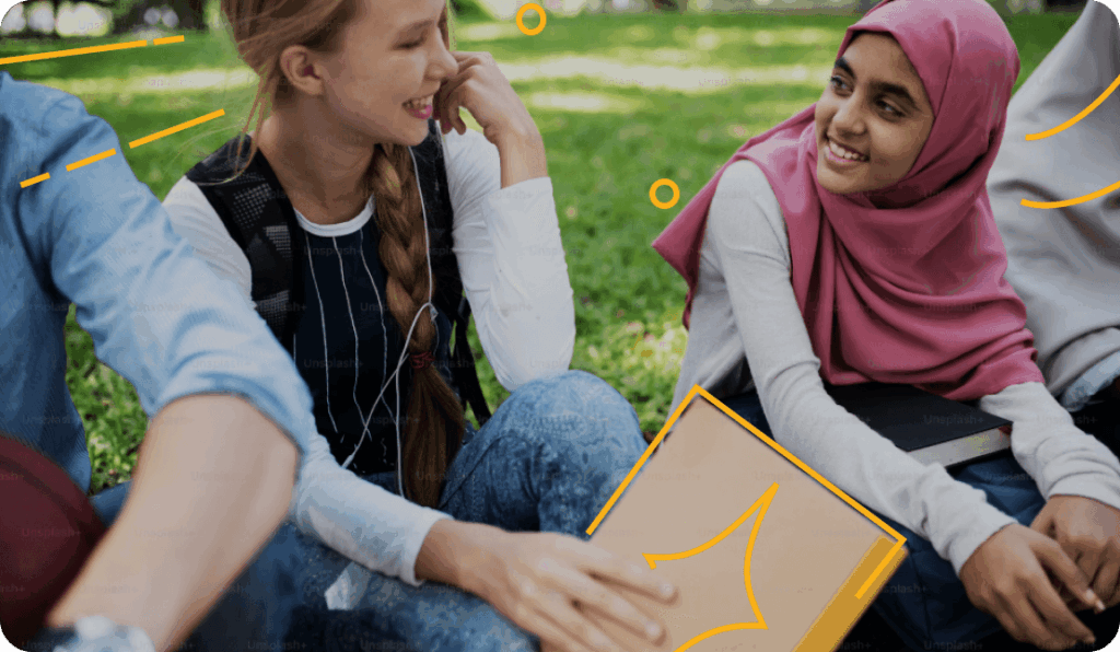 students sitting on the lawn talking to one another